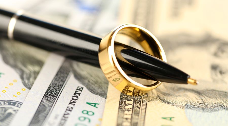wedding ring on pen money in the background
