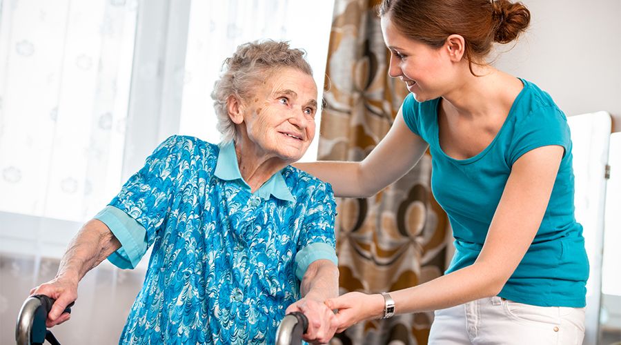 elderly woman being assisted in nursing home