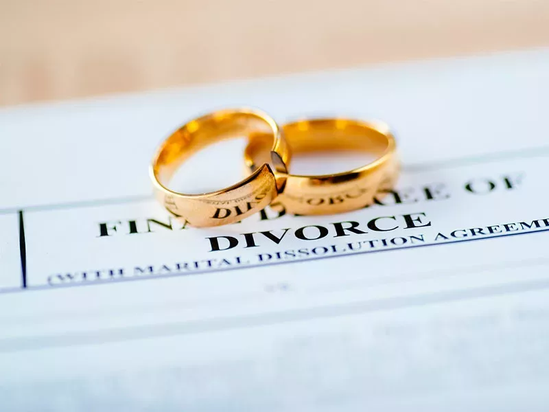 wedding rings on top of a divorce decree paperwork